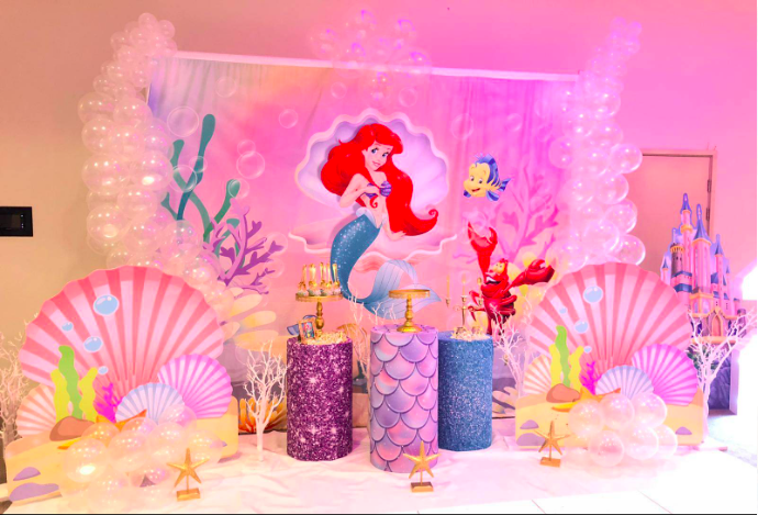 Mermaid themed partying, including mermaid backdrop with organic balloon arch, little mermaid props, little mermaid cake, childrens chair hire, childrens table decoration